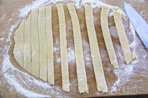 Leaving the strips in place, start with one of the longest (center) strips and lift it, placing it on top of the pie filling 
